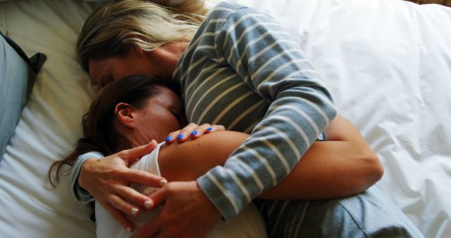 Comforting Hug between Two Women Lying on Bed in Striped Pajamas - Download Free Stock Images Pikwizard.com