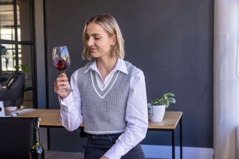 Businesswoman Enjoying Red Wine in Modern Office Lounge