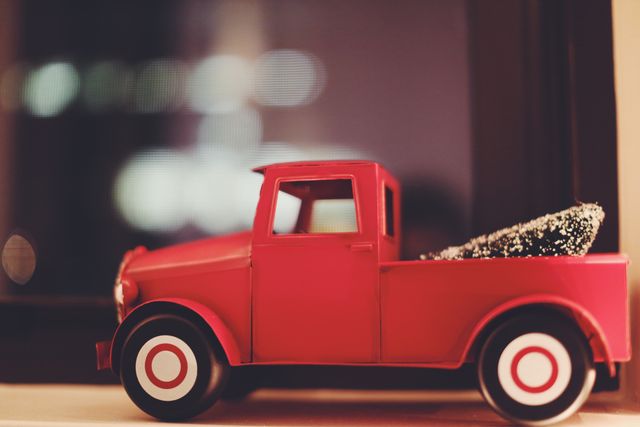 Retro red toy truck with small cargo parked at night. Perfect for use in childhood nostalgia themes, holiday decorations, and vintage-inspired projects. Can be useful in advertising for toys, decorations, and nostalgic content.