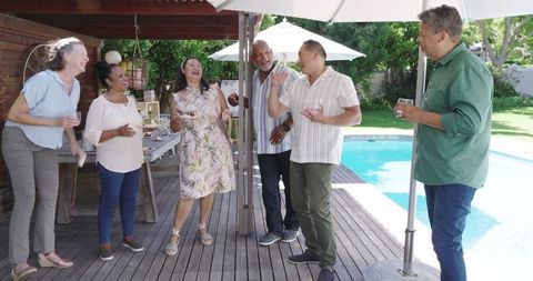 Senior Group Celebrating Friendship at Poolside Garden Party