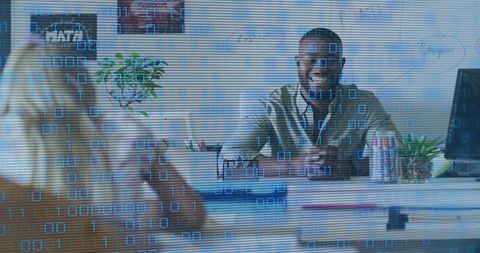 Smiling consultant leaning forward at desk with earbuds, monitor and digital overlay