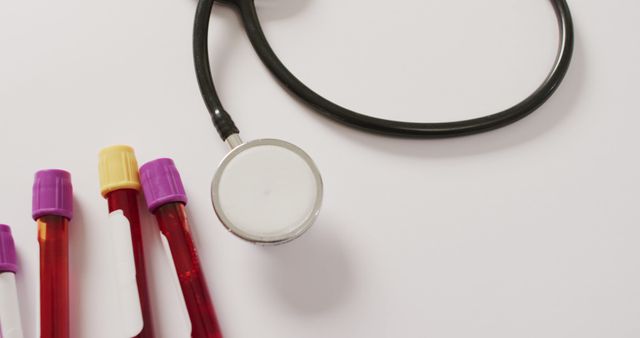 Image of close up of stethoscope with test tubes on pink background. global medicine and healthcare concept.