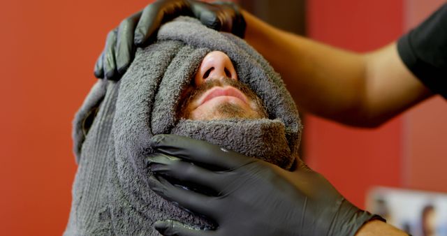 Caucasian man receives a relaxing facial treatment at a spa. A skilled beautician provides a soothing experience in a tranquil wellness center.