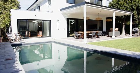 Modern two-story white house with pool and outdoor living area
