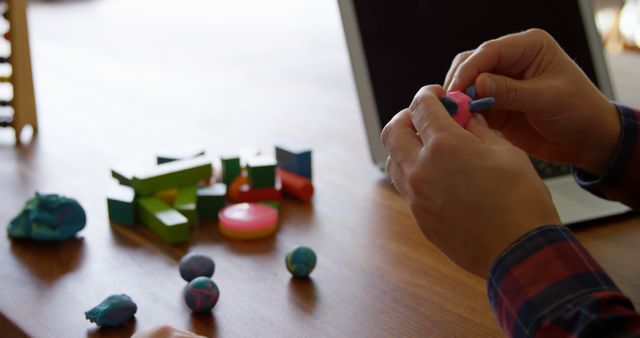 Hands Shaping Clay at Desk with Colorful Building Blocks - Download Free Stock Images Pikwizard.com