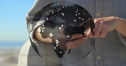 Dotted globe overlay showing global mobile connectivity on seaside promenade, business technology