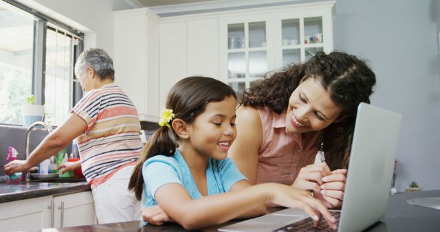 Mother Helping Daughter with Laptop while Grandmother Washing Dishes - Download Free Stock Images Pikwizard.com