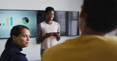 Female Business Leader Presenting Information to Colleagues in Modern Office