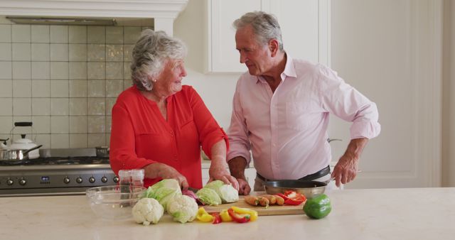 Caucasian senior couple chopping vegetables together in the kitchen at home - Download Free Stock Photos Pikwizard.com