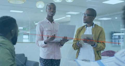 Team Meeting with Laptop and Tablets in Modern Office