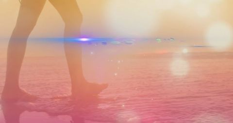 Footprints in sand with vibrant light effects at sunset beach