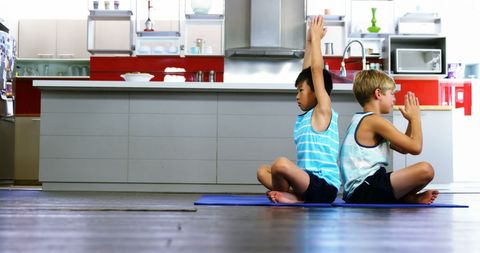 Two boys practicing yoga on kitchen floor encouraging mindfulness