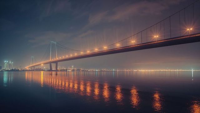 Illuminated Suspension Bridge and Lustrous Cityscape at Night