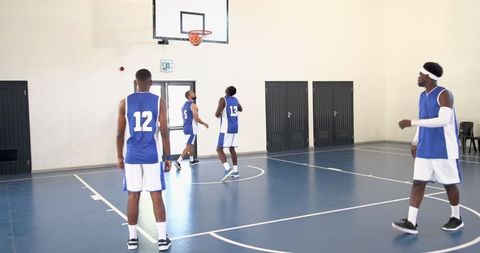 Diverse Basketball Team Practicing in Gym with Blue Jerseys