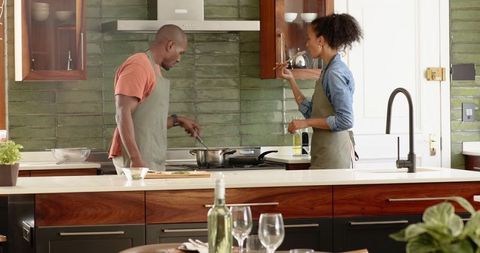 Couple Cooking Together in Stylish Home Kitchen Tasting Homemade Dish