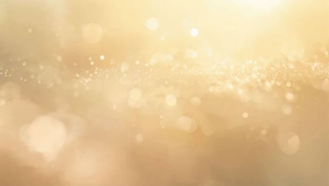 Golden glitter bokeh background with shimmering dust, warm glow and sparkling highlights