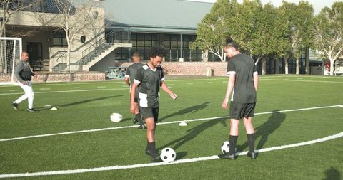 Teen soccer players increasing dribbling skills on school field
