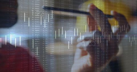 Analyst holding stylus pointing at candlestick chart on glass dashboard for market analysis