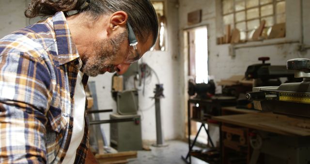 Carpenter Focusing on Woodworking in Workshop - Download Free Stock Images Pikwizard.com