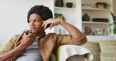 Man Relaxing At Home While Using Smartphone Conversation