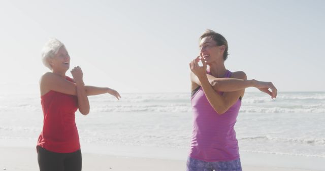 Senior women enjoy a morning stretching routine by the ocean, promoting fitness and a healthy lifestyle. Ideal for topics related to active aging, friendship, outdoor activities, and well-being for mature adults. Perfect for fitness blogs, wellness programs, and advertisements for senior health services and retirement communities.