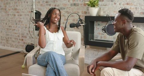 African american duo recording casual conversational podcast in cozy brick-wall home studio