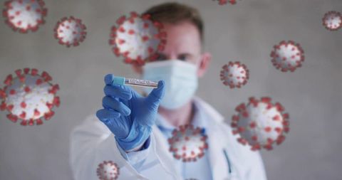Masked doctor holding covid vaccine vial with virus overlay, clinician in lab coat