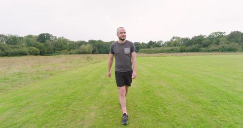 Man jogging on grassy field enjoying fresh air