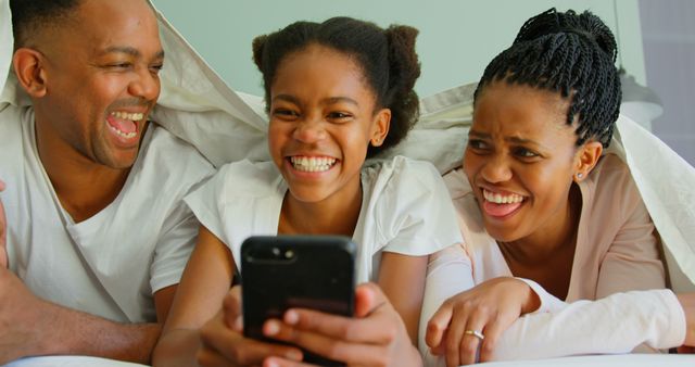 Joyful Family Laughing While Using Smartphone in Bed - Download Free Stock Images Pikwizard.com