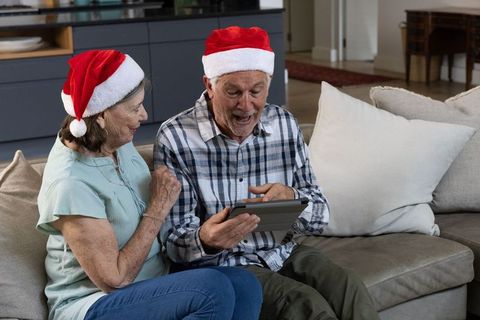 Happy Senior Couple with Tablet Celebrating Christmas at Home