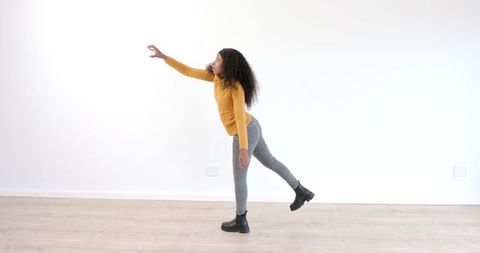 Young Woman Balancing Elegantly on One Leg in Minimalistic Space