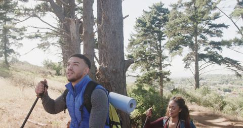 Diverse Couple Enjoying Hiking Adventure in Sunny Forest