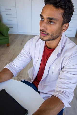 Focused Indian Man Using Tablet in Casual Home Environment