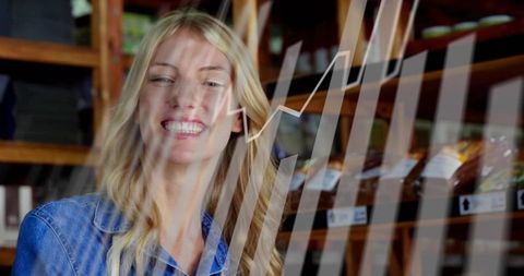 Young woman smiling in bakery, rising sales graph overlay illustrating retail growth