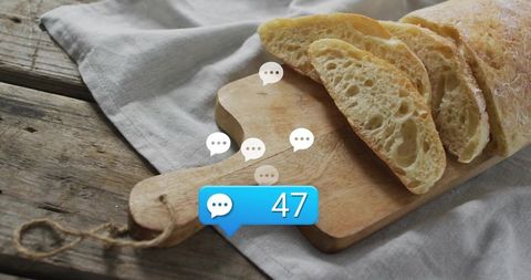 Sliced ciabatta loaf sitting on rustic wooden cutting board with social chat notification