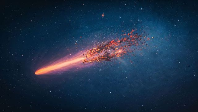 Gliding comet with fiery core and fragmented debris trailing through deep starfield