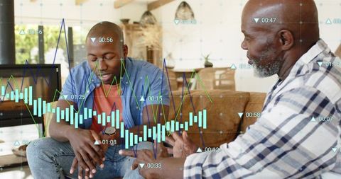Two Men Analyzing Financial Data with Interactive Charts and Conversation in Living Room