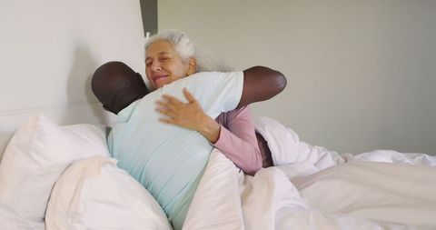 Senior Couple Embracing on Bed for Comfort and Intimacy