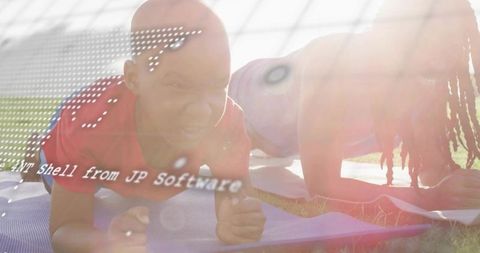 Father and son performing plank on yoga mats in sunlit park with lens flare