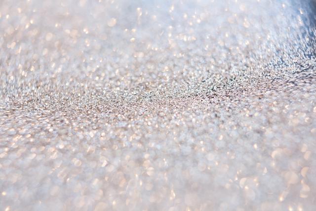 Full frame of silver glitter sparkling with bokeh effect. Ideal for festive backgrounds, holiday decorations, Christmas cards, party invitations, and celebratory designs. Perfect for adding a touch of shimmer and shine to any project.