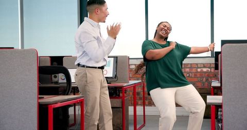 Colleagues Joyfully Dancing in Office to Celebrate Success