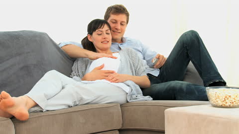 Couple Relaxing on Couch Awaiting Baby