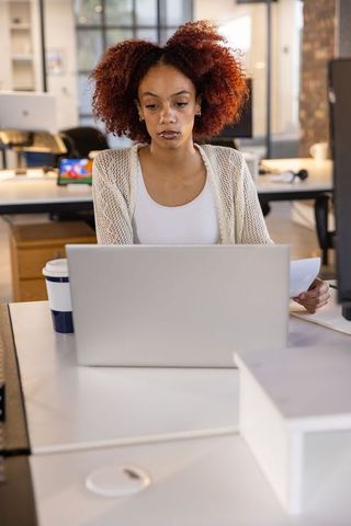 Professional Woman Analyzing Documents in Modern Office