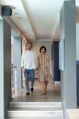 Couple walking hand in hand in modern corridor