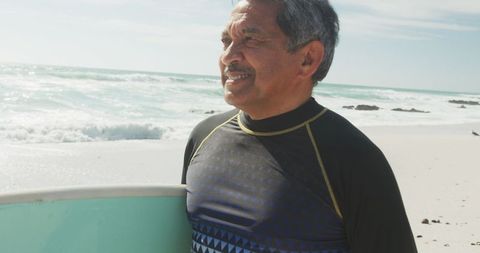 Senior Man Enjoying Surfing by Ocean Beach
