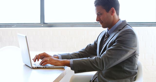 Focused Businessman Working on Laptop in Bright Office - Download Free Stock Images Pikwizard.com