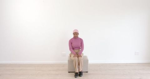 Woman in Cozy Pink Attire Seated on Neutral Background - Download Free Stock Images Pikwizard.com