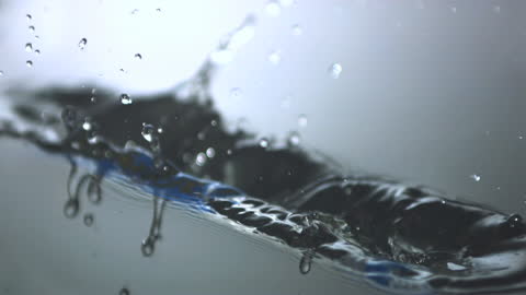 Blue Toothbrush Splashing into Water with Droplets in Motion