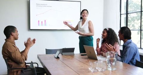 Diverse team celebrating a business success in modern office
