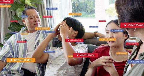 Family relaxing on couch while receiving social media notifications and streaming video